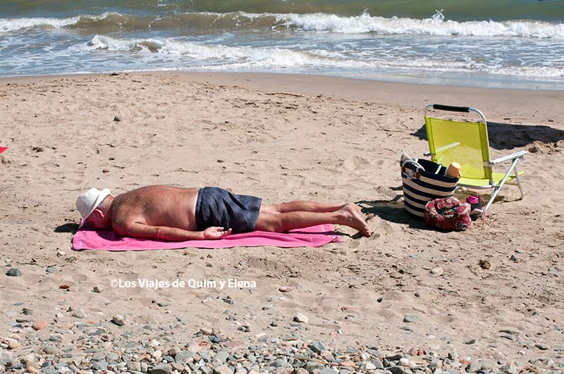 Un bañista tumbado/caído en la playa de la Llosa